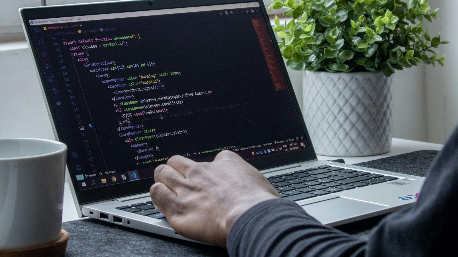 A developer writing website code on a laptop